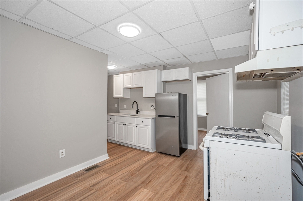 90 Appleton Street, Unit U:7 Lowell, MA 01852 - Photo 4 of 13 a kitchen with refrigerator and cabinets