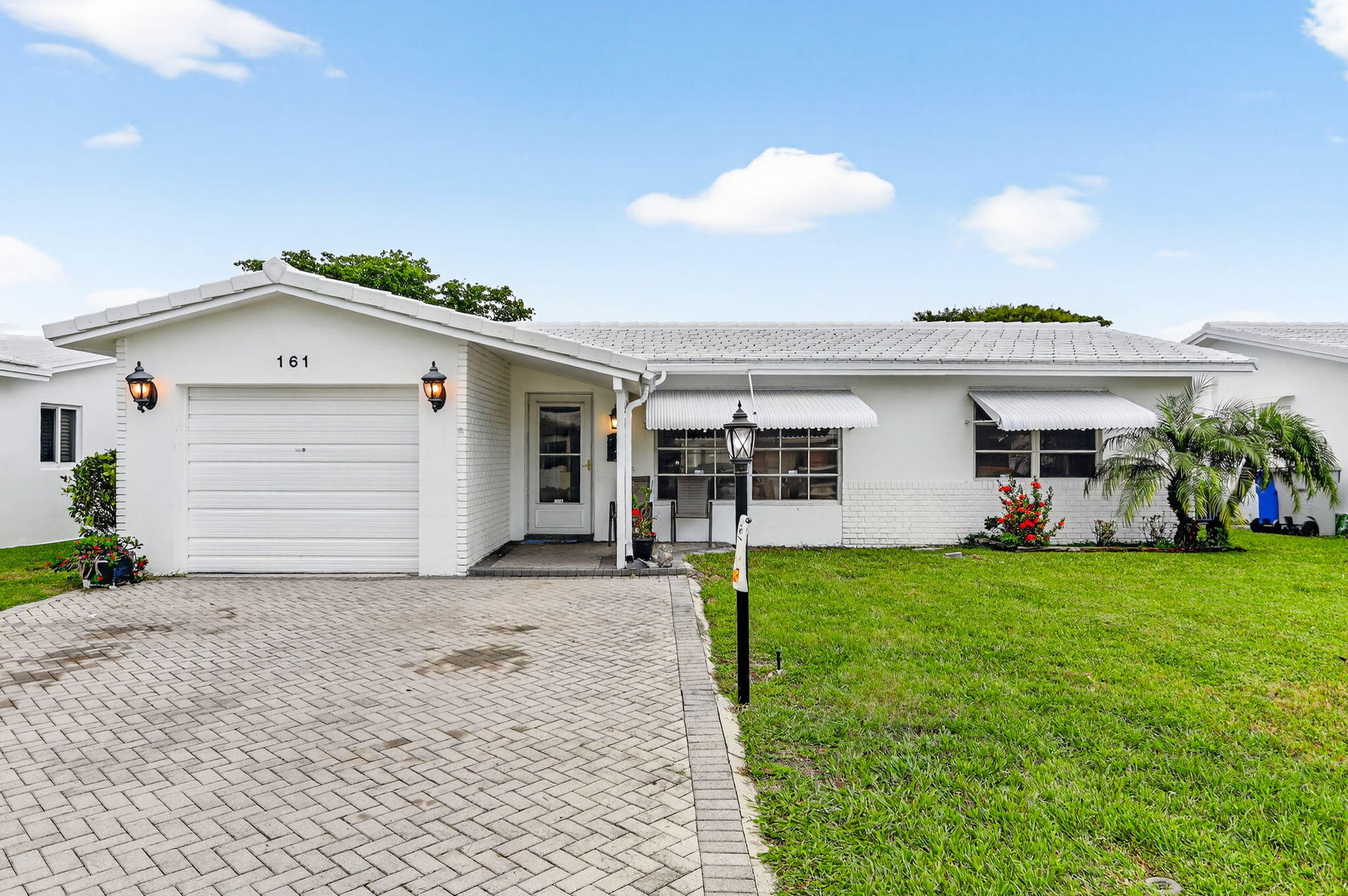 161 Northwest 24th Court Pompano Beach, FL 33064 - Photo 2 of 45 a front view of a house with a garden and plants