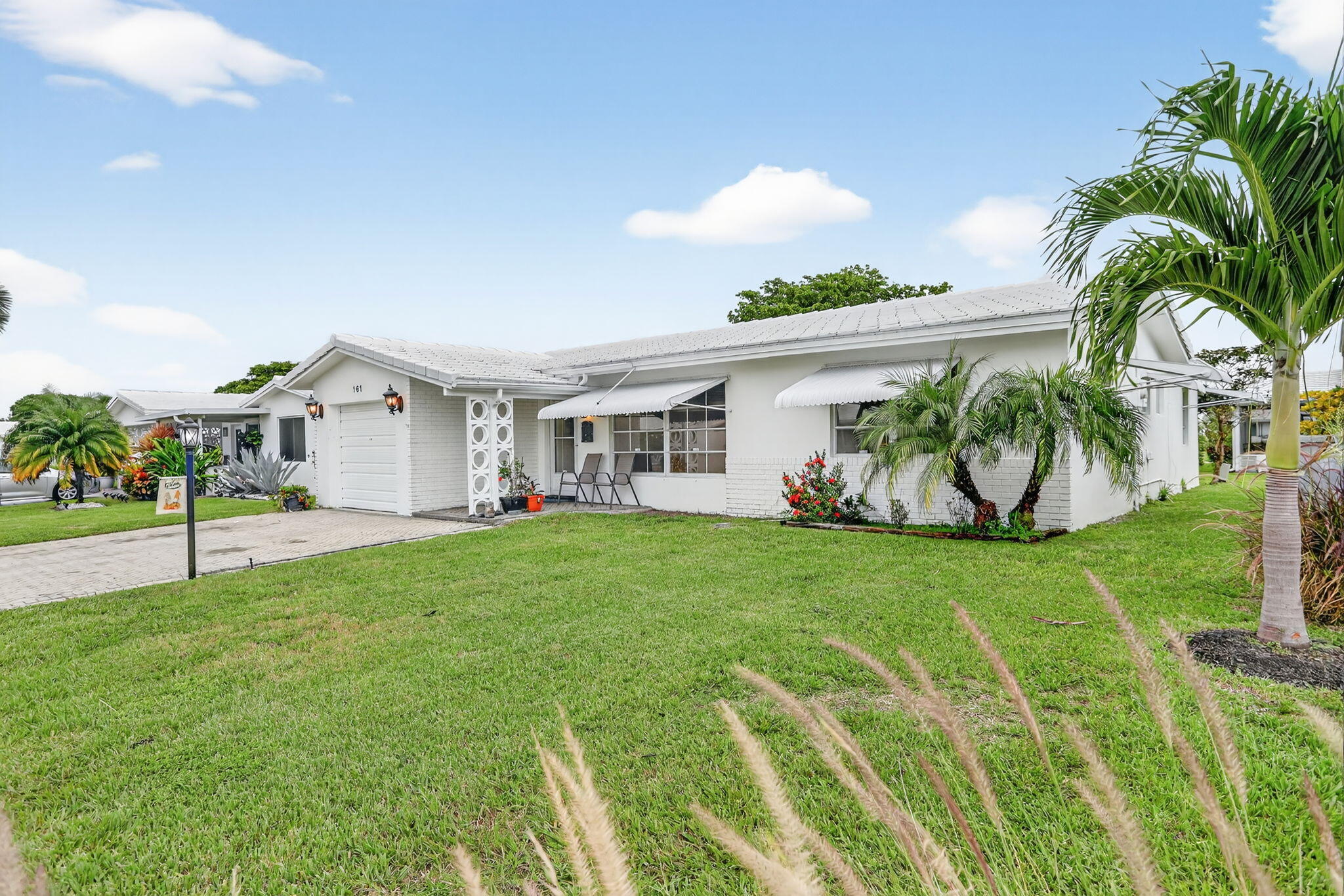 161 Northwest 24th Court Pompano Beach, FL 33064 - Photo 23 of 45 a white house with a big yard and potted plants