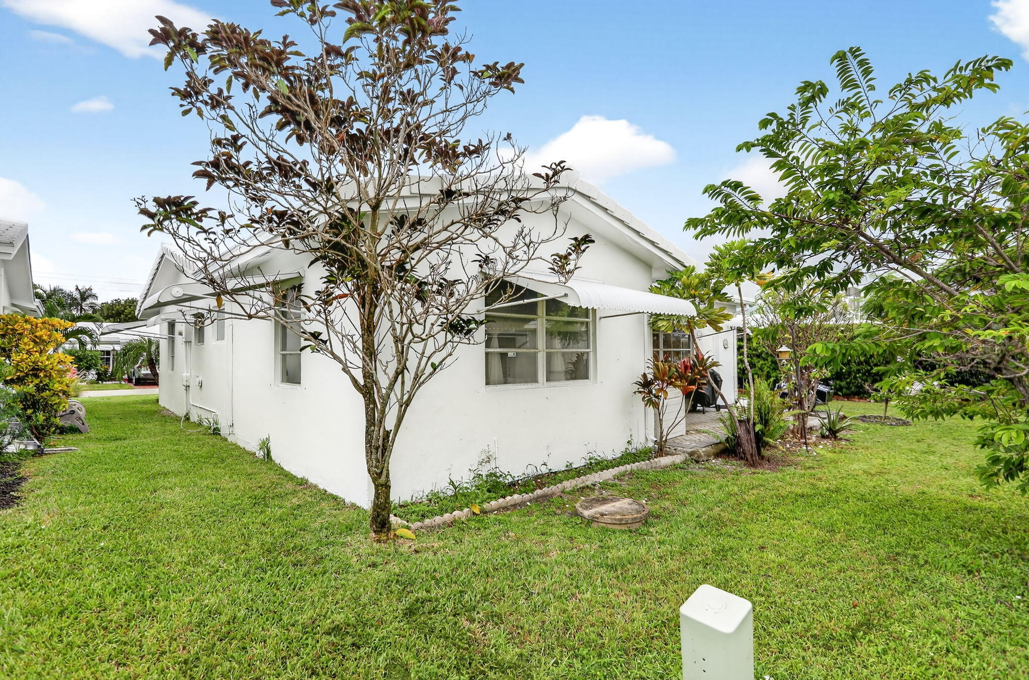 161 Northwest 24th Court Pompano Beach, FL 33064 - Photo 25 of 45 a view of a white house with a yard and sitting area