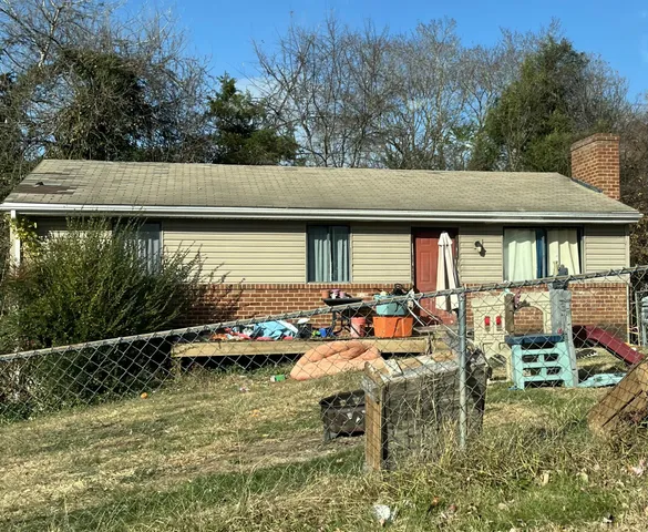 a view of swimming pool with lawn chairs and plants