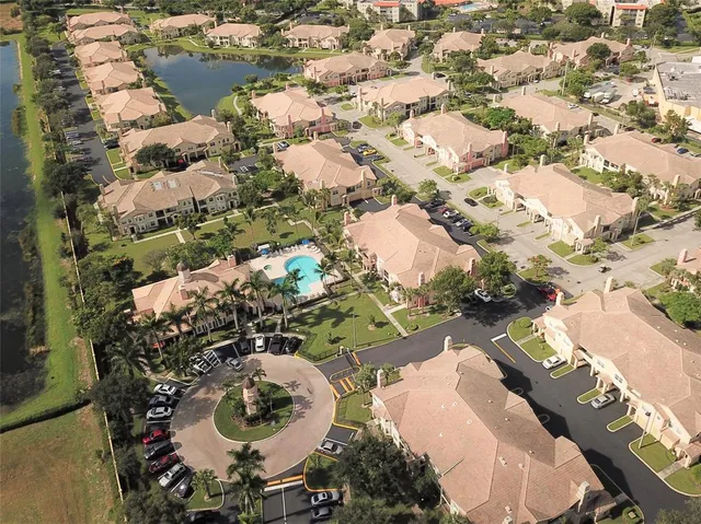 an aerial view of a house with a yard and lake view in back