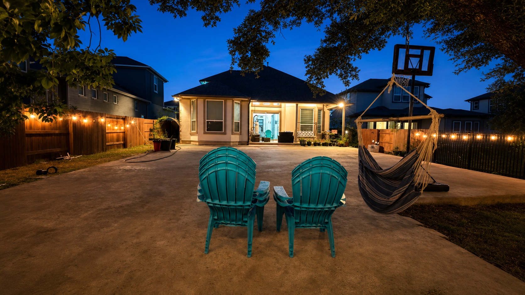 A private backyard oasis illuminated by charming string lights, perfect for evening relaxation.