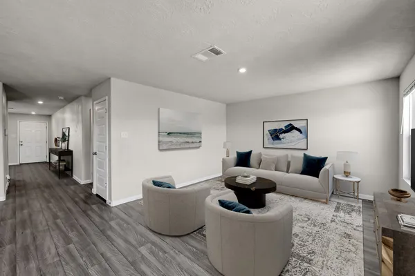 a living room with furniture and a wooden floor