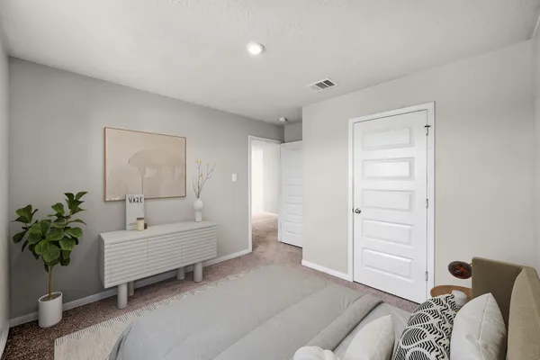 a spacious bedroom with a bed and a couch