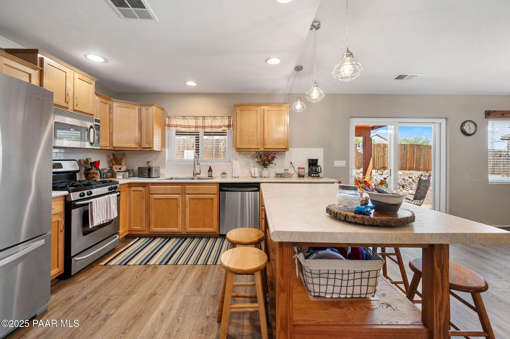 17798 East Trails End Road Mayer, AZ 86333 - Photo 9 of 30 a kitchen with stainless steel appliances granite countertop a stove a sink dishwasher a dining table and chairs with wooden floor