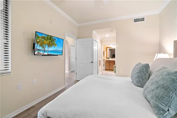 a bedroom with a large bed and a painting on the wall