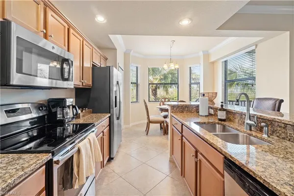 a kitchen with stainless steel appliances granite countertop a sink stove and cabinets