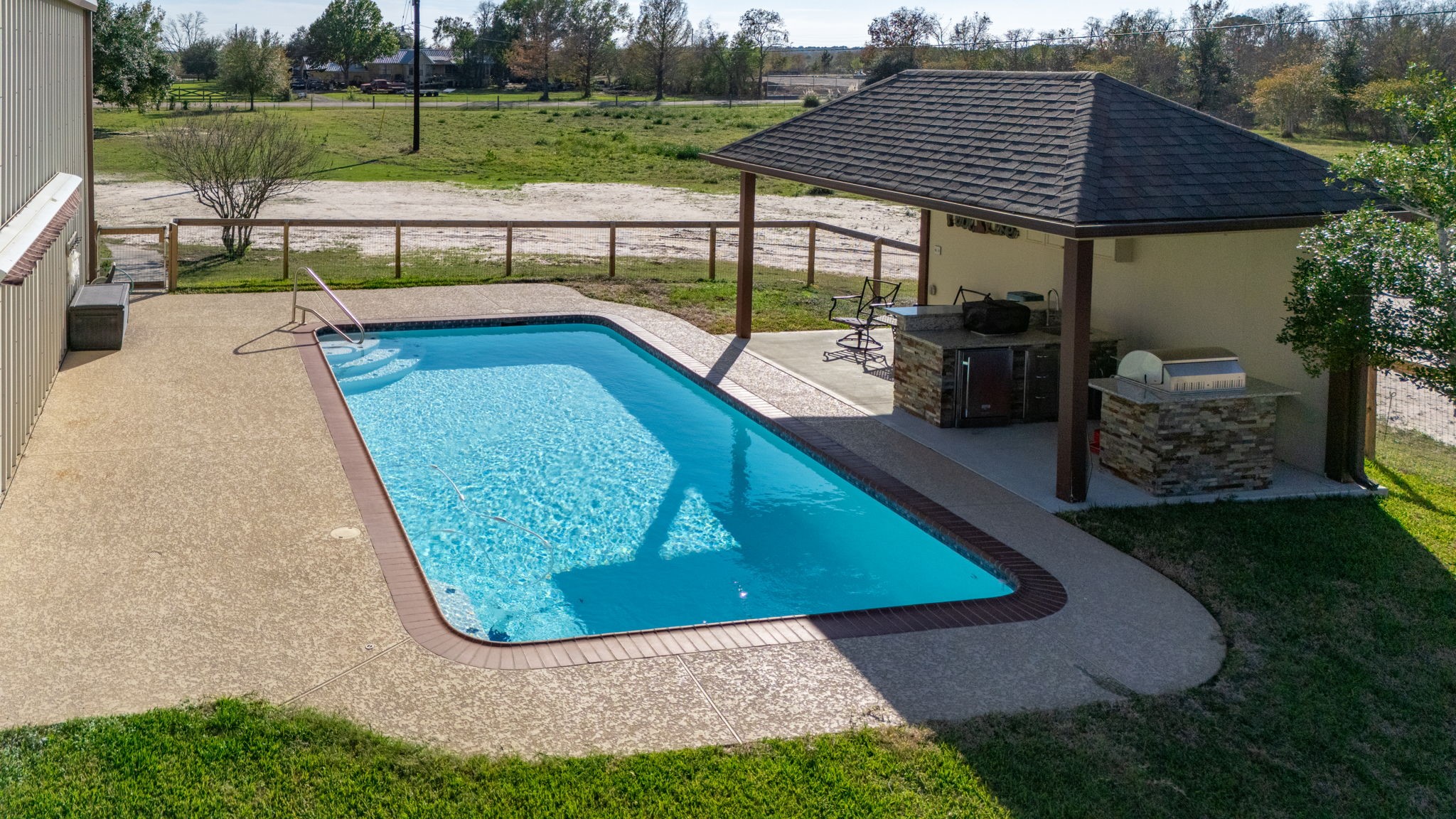 26253 Sharp Road Katy, TX 77493 - Photo 18 of 25 The in-ground pool is surrounded by an expansive patio offering plenty of room for lounging, sunbathing, and enjoying outdoor gatherings in style.