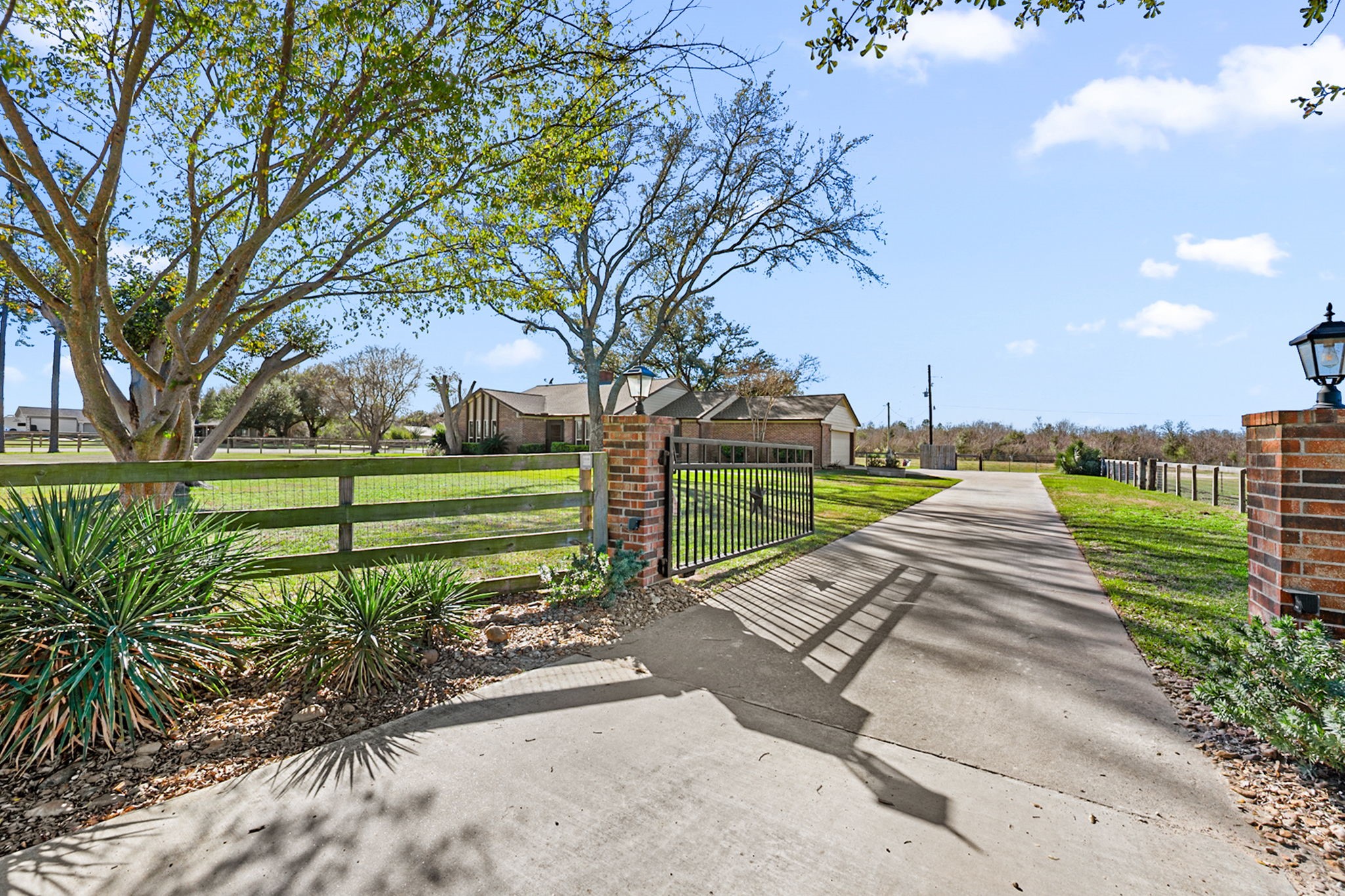 26253 Sharp Road Katy, TX 77493 - Photo 3 of 25 A gated, tree-lined drive through the automatic gate sets the tone for this private retreat—offering a welcoming arrival, wide open green space, and the peaceful sense of country living with room to spread out and explore.