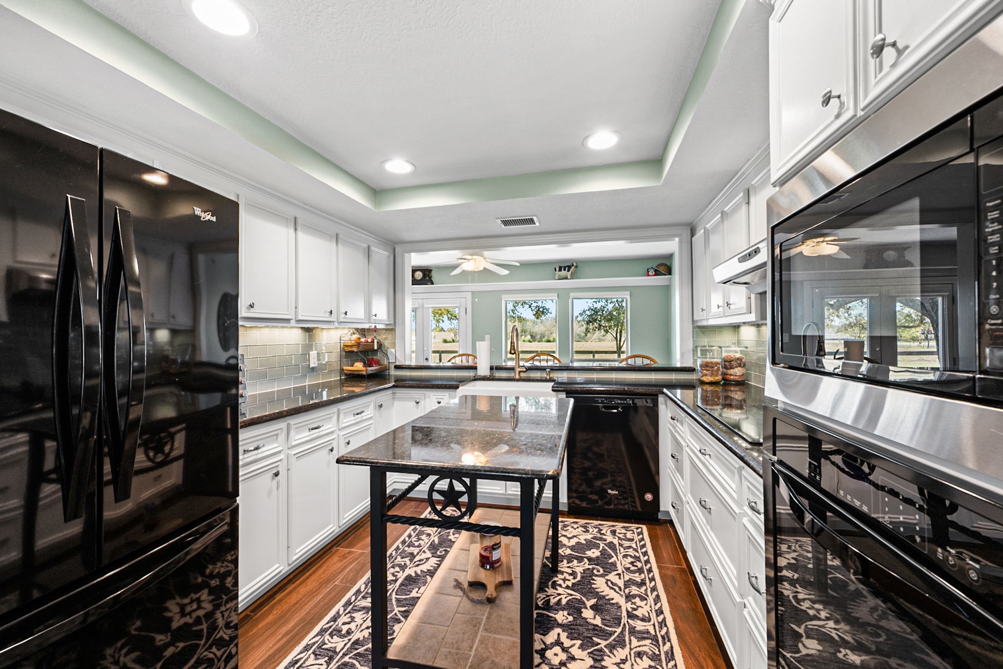 26253 Sharp Road Katy, TX 77493 - Photo 7 of 25 Step into this beautifully designed kitchen, featuring tray ceilings, rich white cabinetry with under cabinet lighting, Granite countertops, and high end appliances.