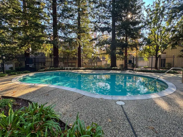 an aerial view of a residential houses with outdoor space and trees