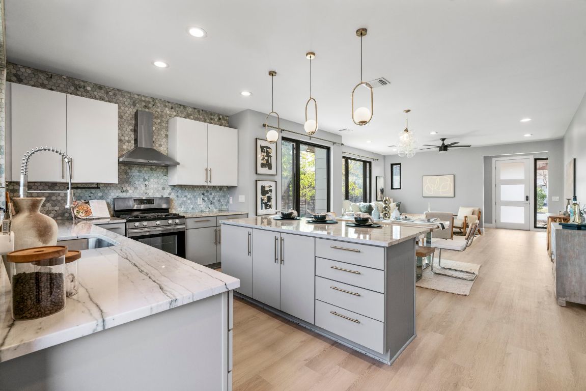 3612 Thompson Street, Unit 1 Austin, TX 78702 - Photo 16 of 40 A chef-forward kitchen anchors the main level with a large island, sleek cabinetry, and statement lighting.
