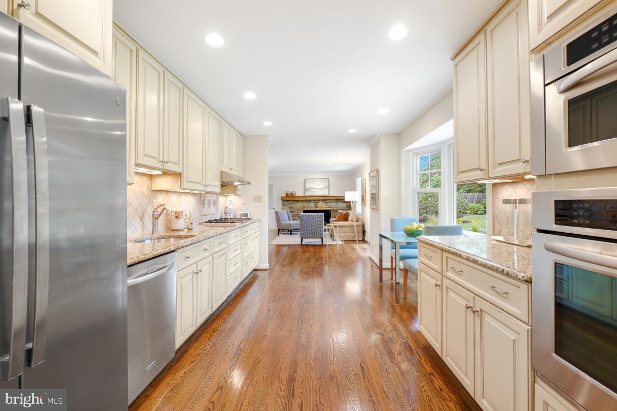 11321 Marcliff Road North Bethesda, MD 20852 - Photo 10 of 48 a kitchen with stainless steel appliances granite countertop a refrigerator a stove top oven a sink dishwasher and white cabinets with wooden floor