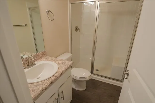 a bathroom with a granite countertop sink toilet and shower