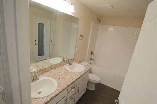 a bathroom with a granite countertop sink toilet and shower