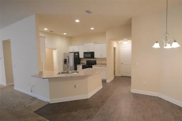 a view of kitchen with refrigerator sink and stove