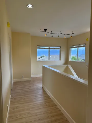 a view of room with window and wooden floor