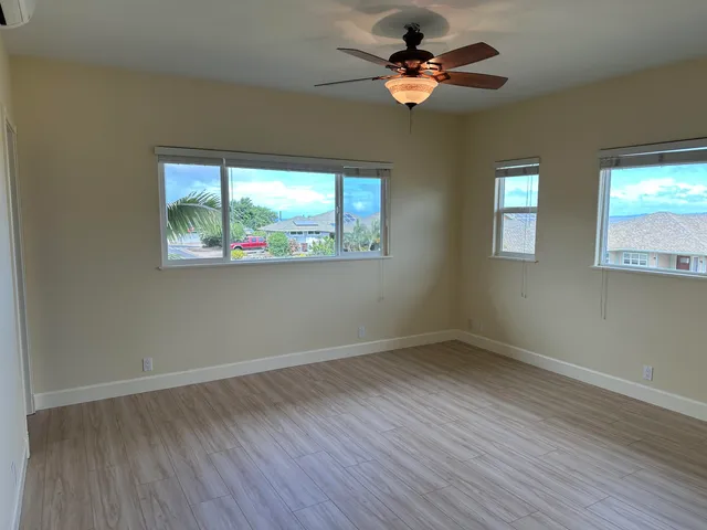 a view of room with window ceiling fan and wooden floor