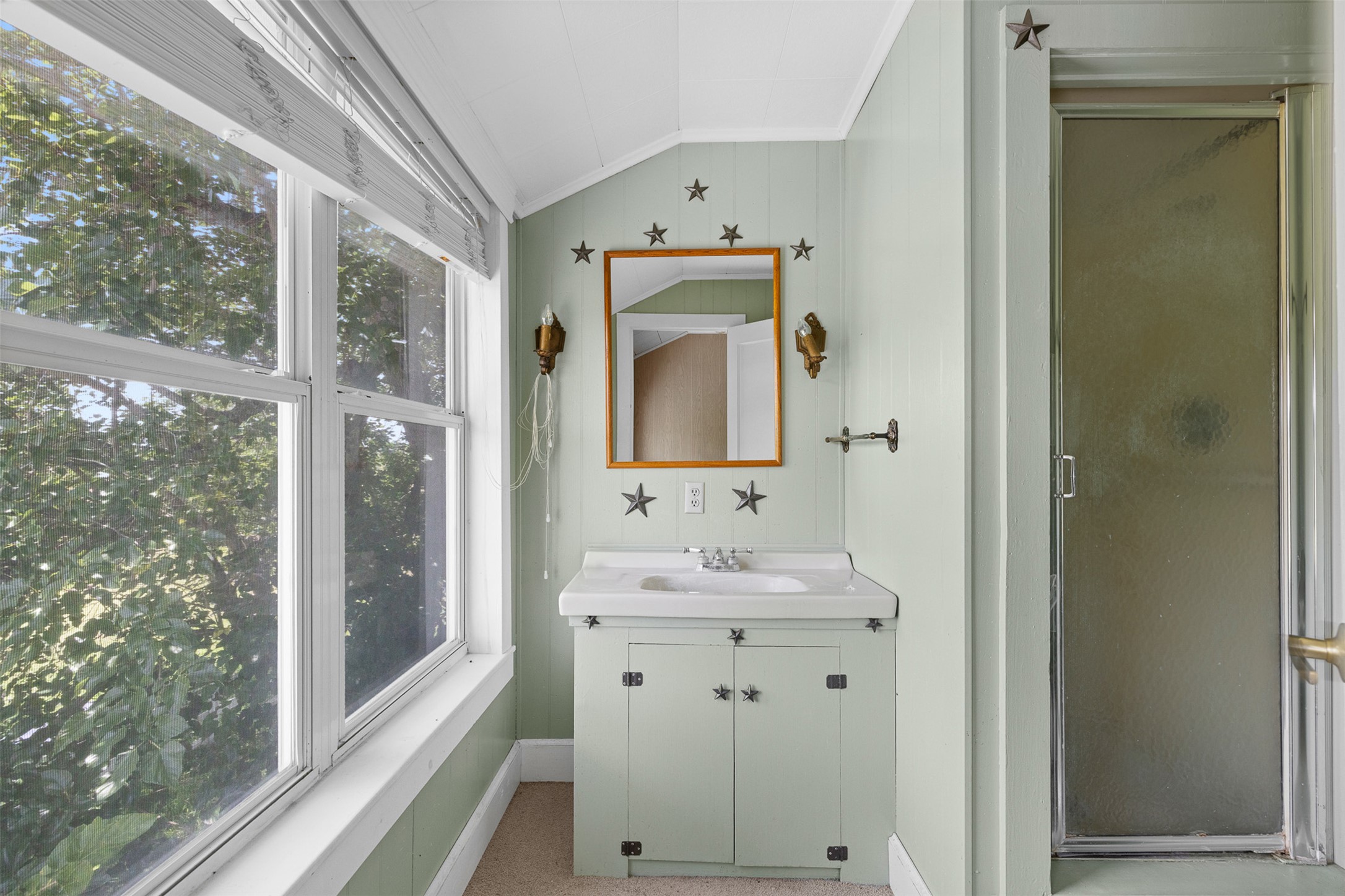 763 Upper Elgin River Road Elgin, TX 78621 - Photo 2 of 40 A well-lit bathroom features a vanity, mirror, and shower, all bathed in natural light from the large windows.