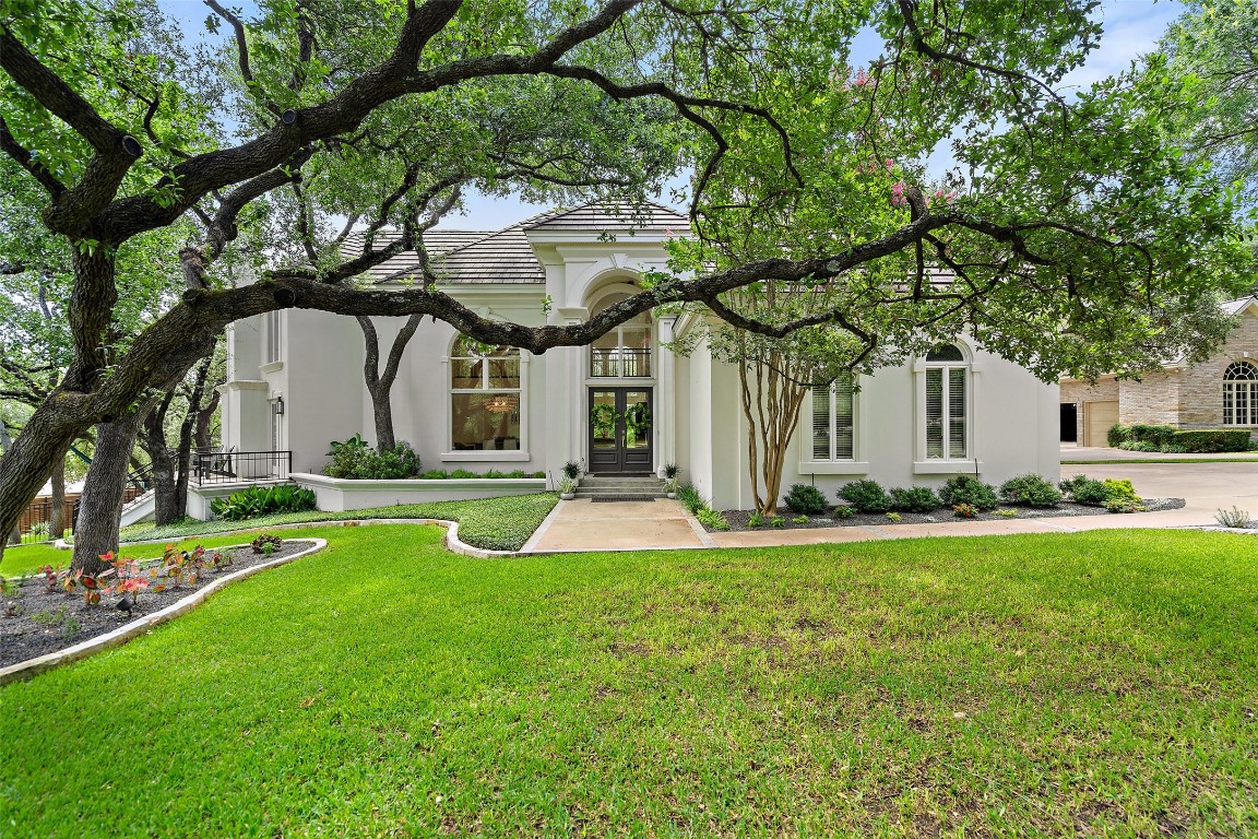 a front view of a house with yard and green space