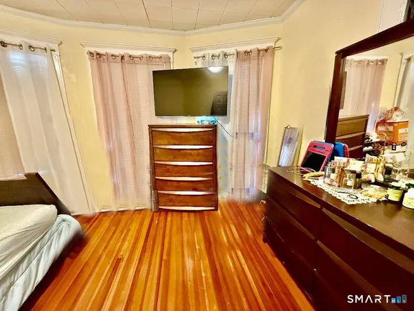 a living room with a bed and a flat screen tv