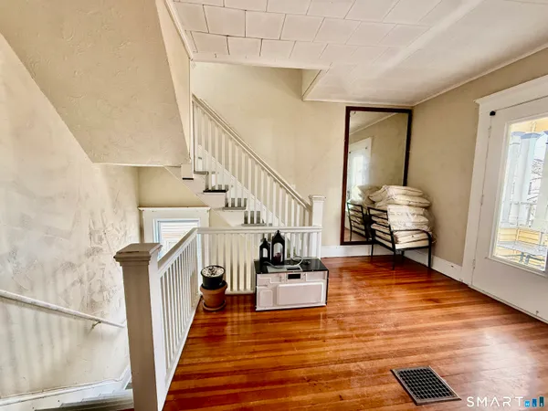 a view of entryway and hall with wooden floor