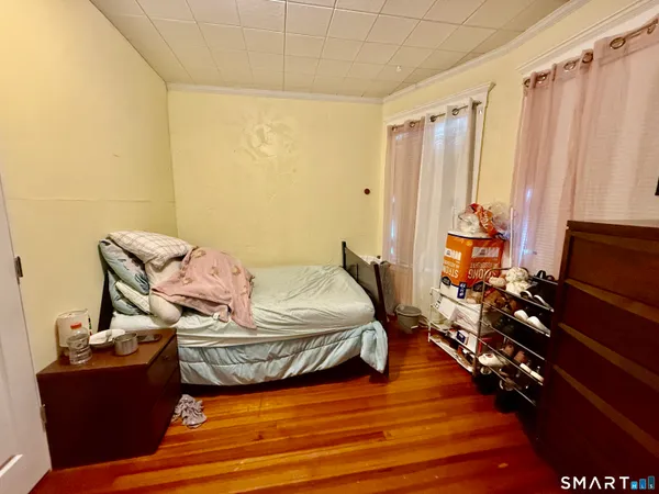 a bedroom with a bed and wooden floor