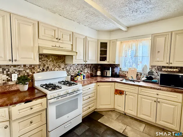 a kitchen with granite countertop a stove sink and cabinets