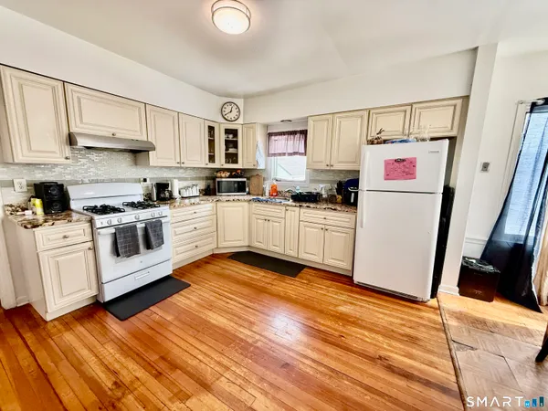 a kitchen with white cabinets and white appliances