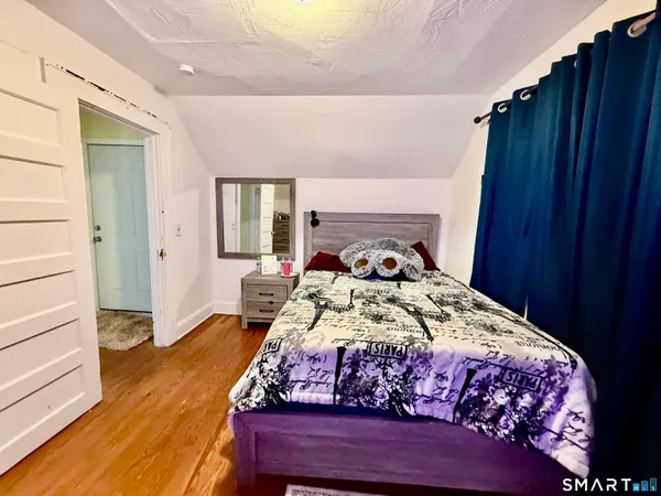 a bedroom with a bed and wooden floor
