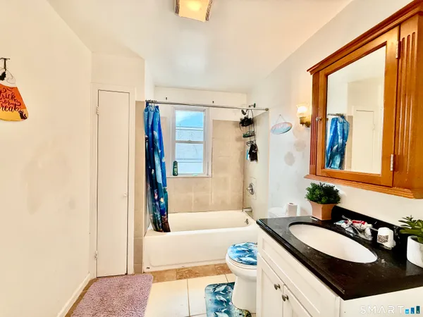 a bathroom with a granite countertop tub sink and mirror