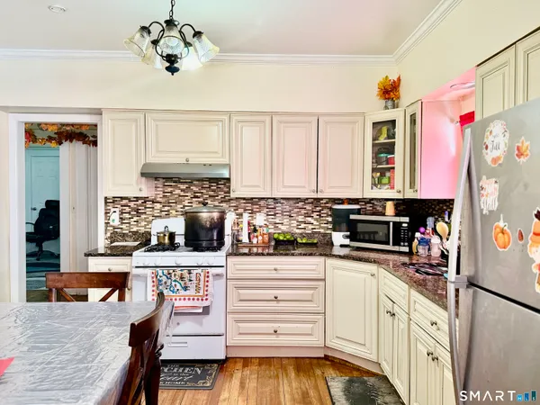 a kitchen with stainless steel appliances granite countertop a refrigerator sink stove and cabinets