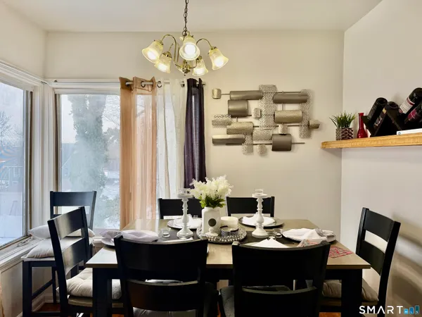 a dining room with furniture a chandelier and window