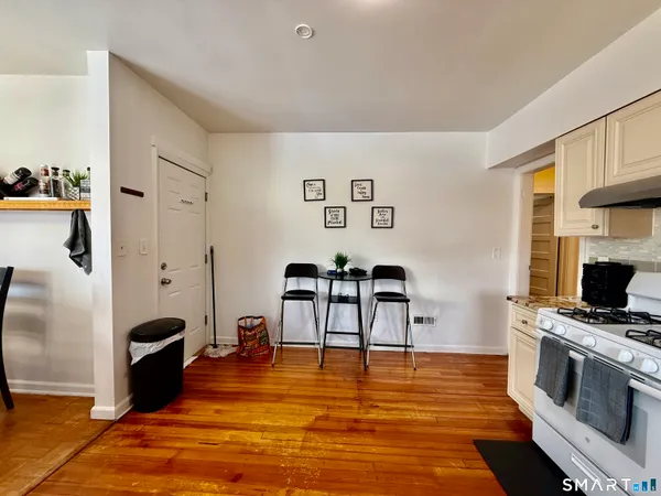 a large white kitchen with stainless steel appliances granite countertop a stove and a refrigerator