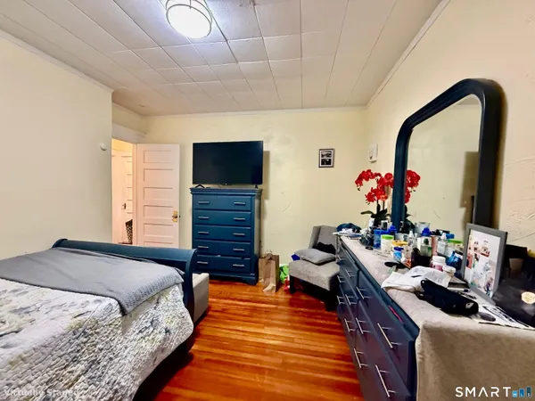 a bed room with a bed tv and a window