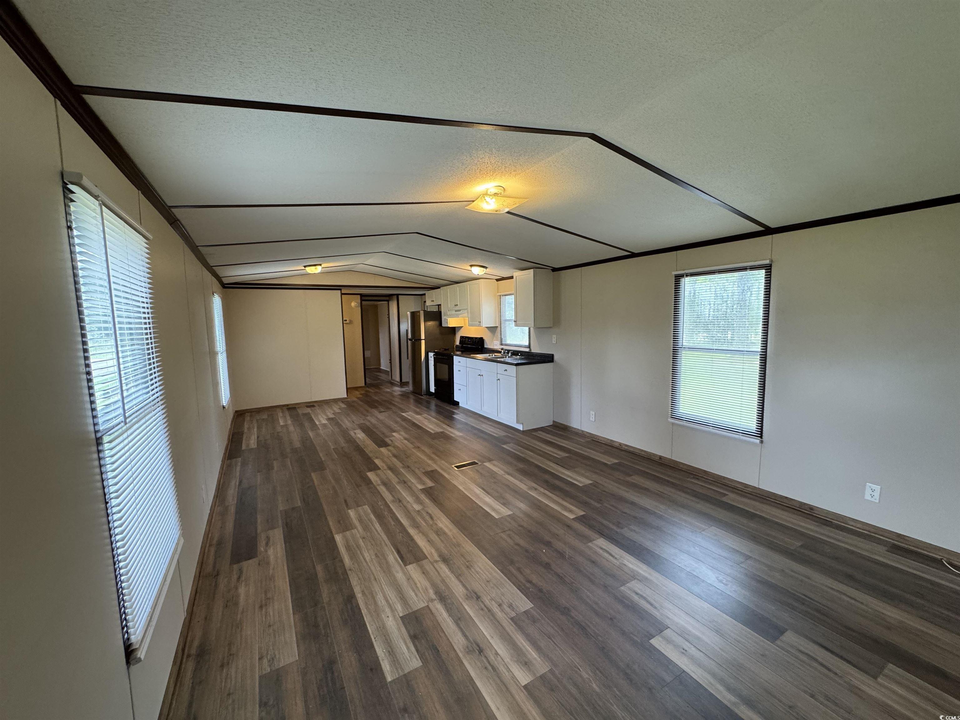 Tbd Still Pond Road Conway, SC 29526 - Photo 6 of 18 Unfurnished living room featuring vaulted ceiling, dark wood-style floors, a textured ceiling, and crown molding