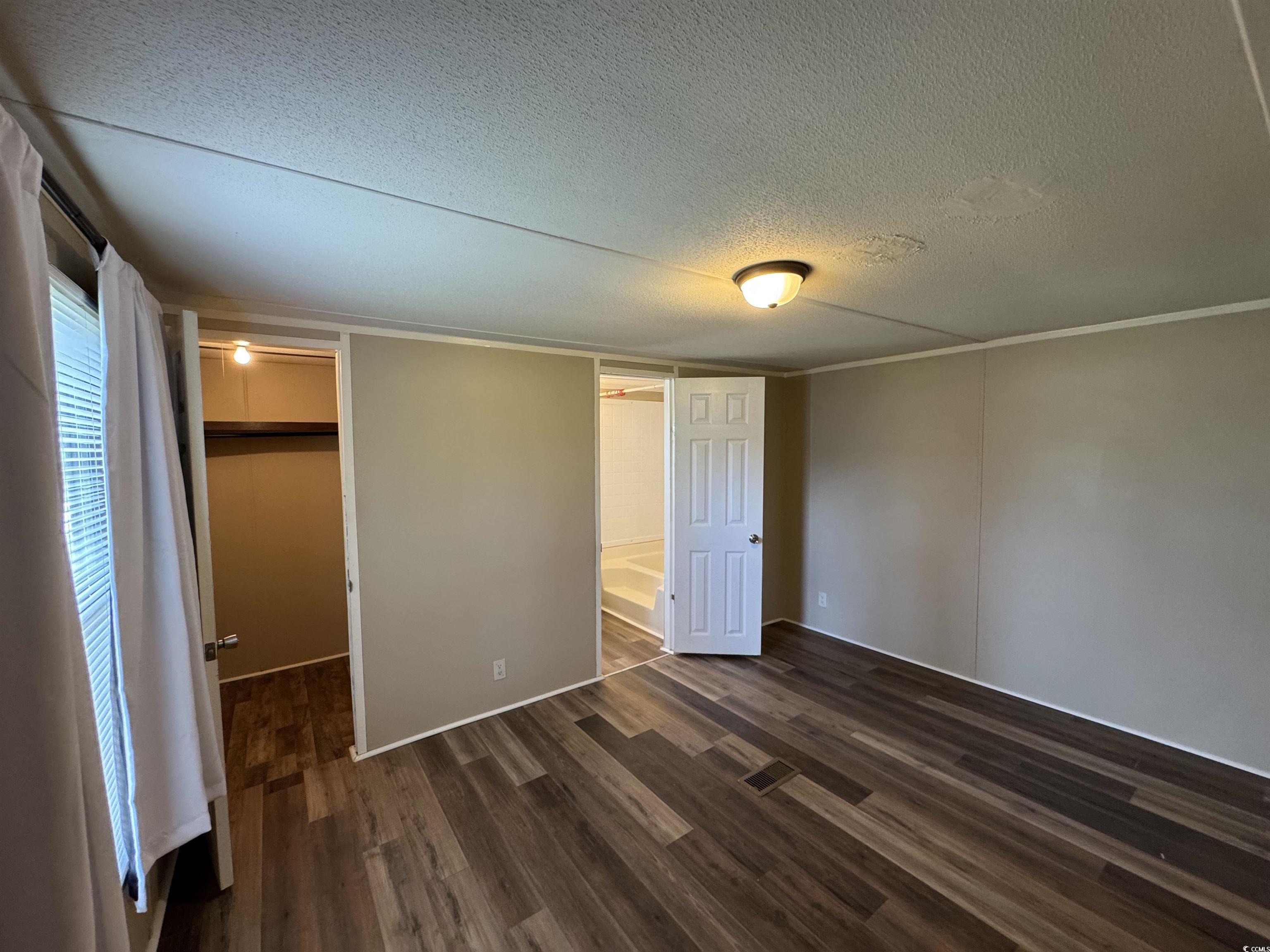 Tbd Still Pond Road Conway, SC 29526 - Photo 10 of 18 Unfurnished bedroom with dark wood finished floors, a textured ceiling, and a spacious closet
