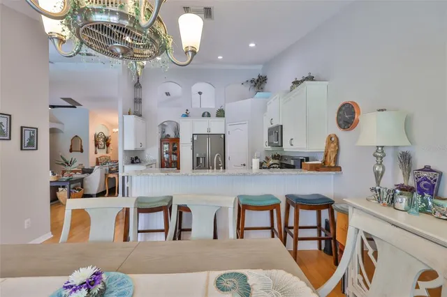a dining room with furniture a chandelier and wooden floor