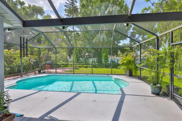 a living room with furniture a chandelier and a large window
