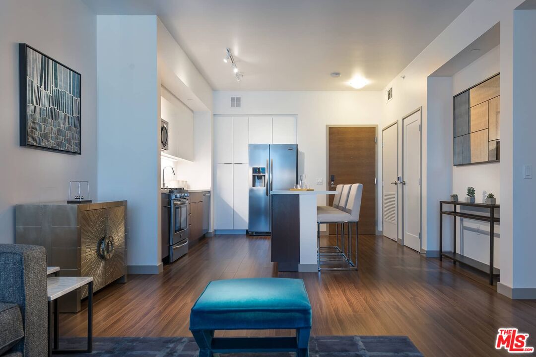 3033 Wilshire Boulevard, Unit 1113 Los Angeles, CA 90020 - Photo 11 of 31 a living room with stainless steel appliances furniture and a wooden floor