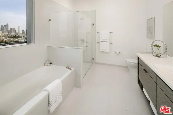 a bathroom with a tub sink and mirror