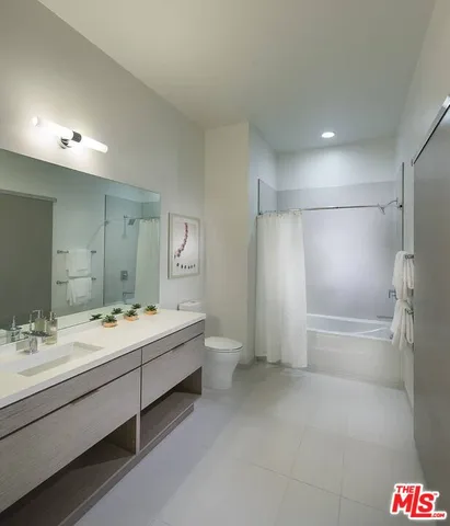 a bathroom with a double vanity sink mirror and shower
