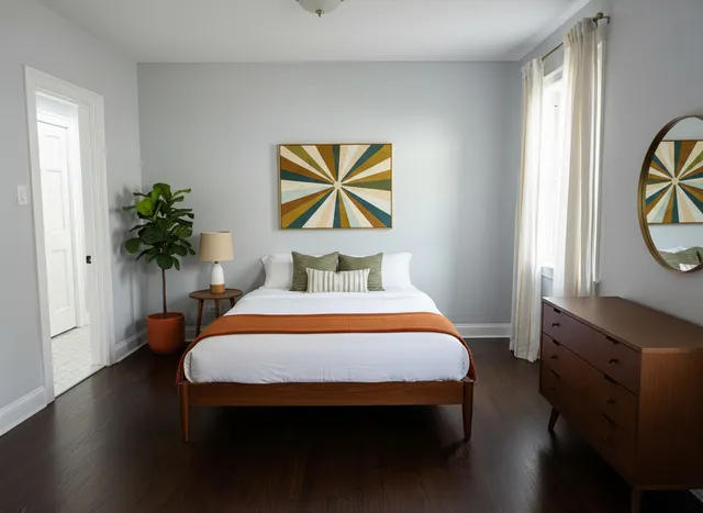 a bedroom with a bed and a potted plant on the dresser