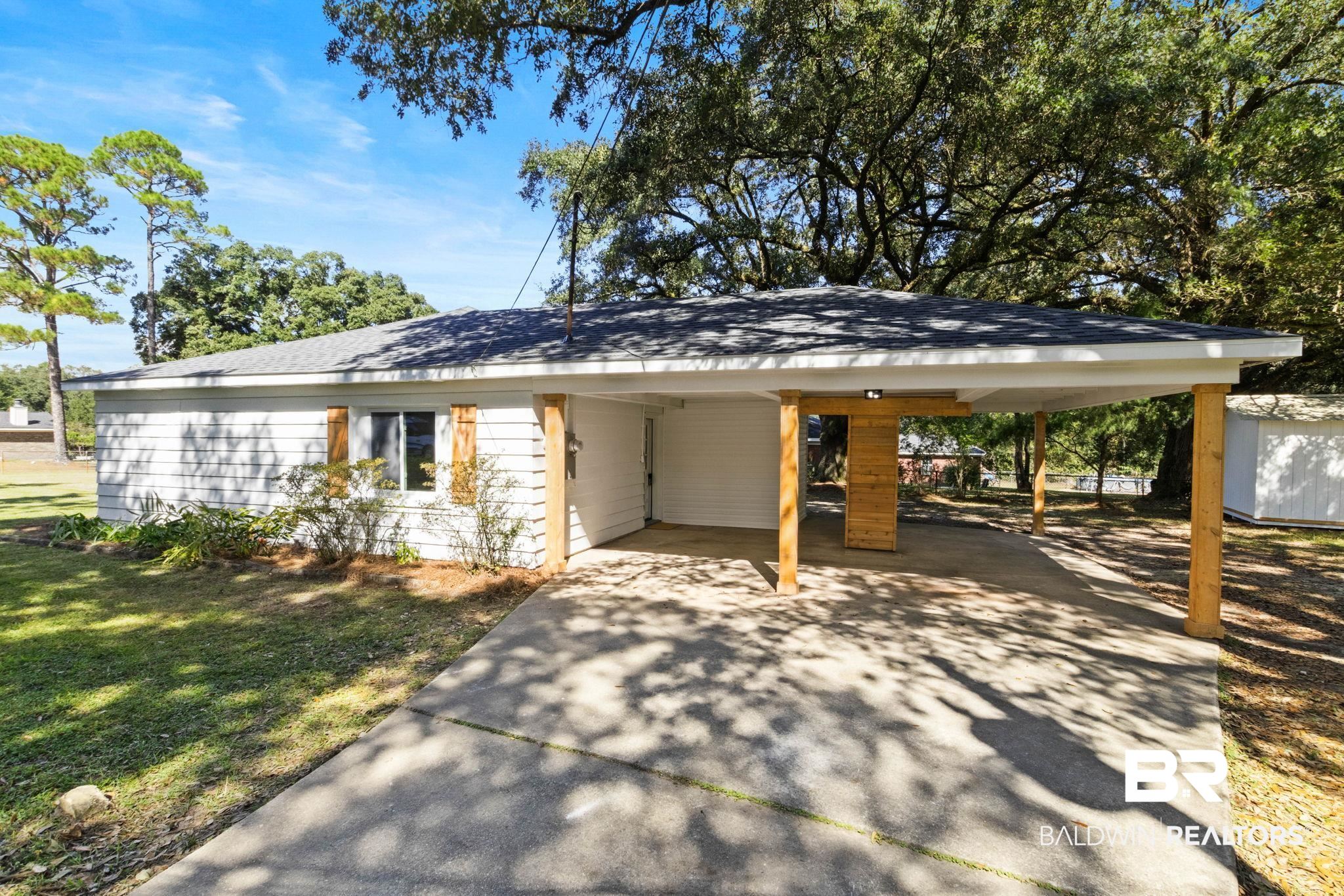 618 Pine Street Saraland, AL 36571 - Photo 3 of 41 View of side of home with an attached carport, concrete driveway, and roof with shingles