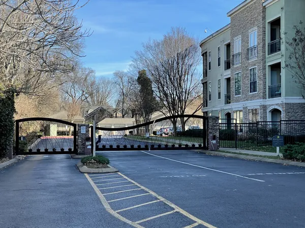 a view of building with lot of cars and trees