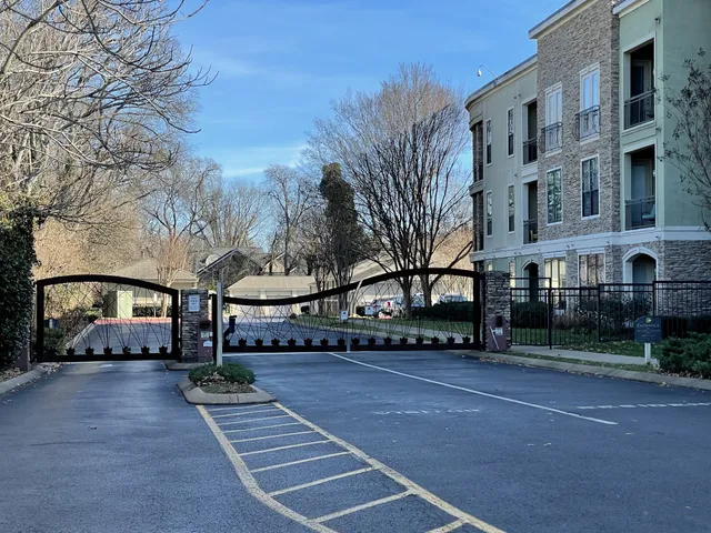 a view of building with lot of cars and trees