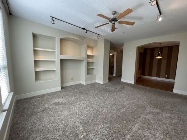 wooden floor in an empty room with a ceiling fan