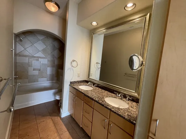 a bathroom with a granite countertop sink and a mirror