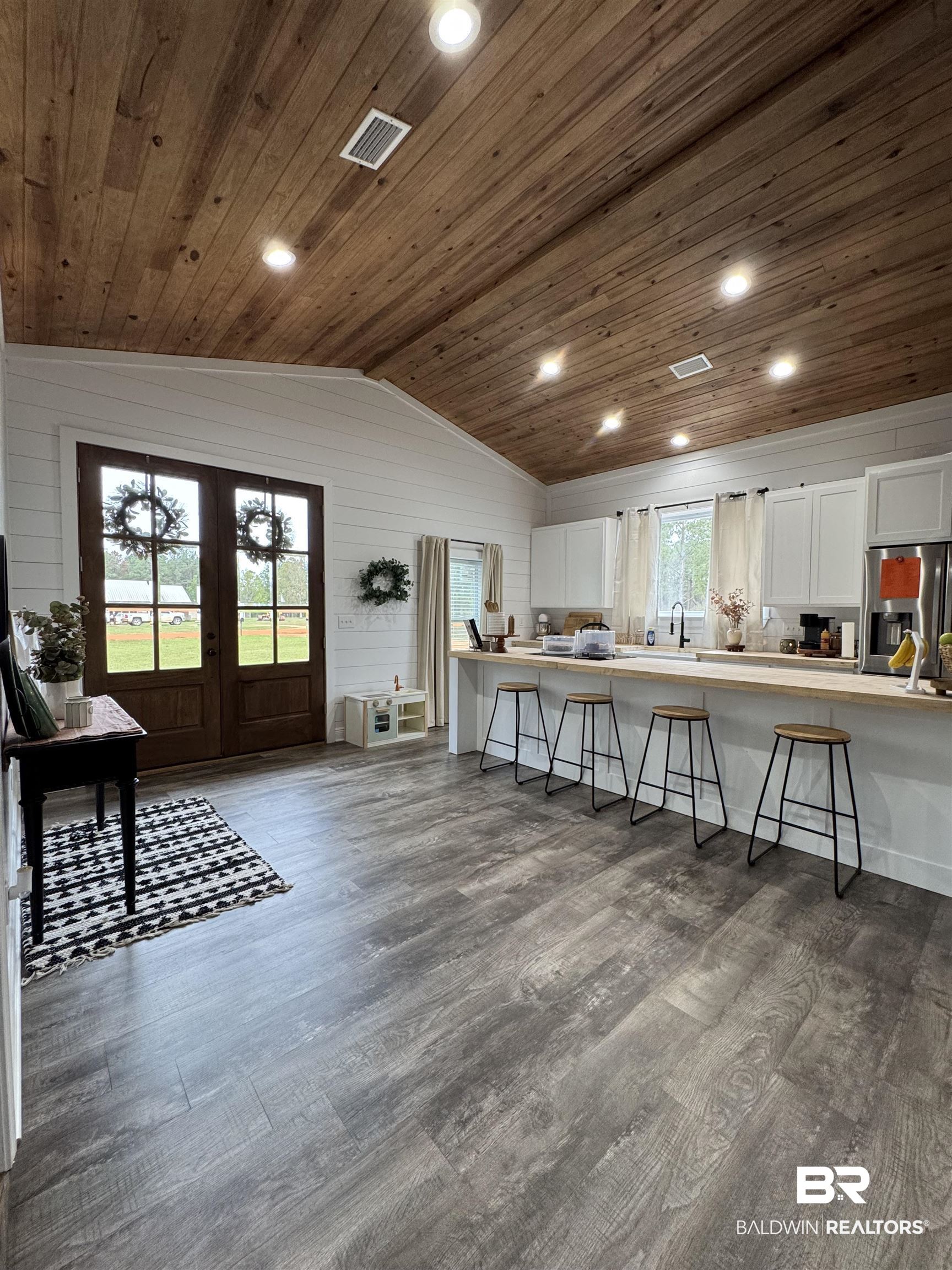 370 Dianne Road Frisco City, AL 36445 - Photo 13 of 41 Kitchen with wood ceiling, vaulted ceiling, a kitchen breakfast bar, and white cabinets